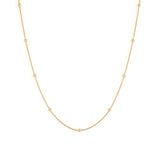 A gold-colored necklace with a chain link design and small spherical embellishments evenly spaced along the length.