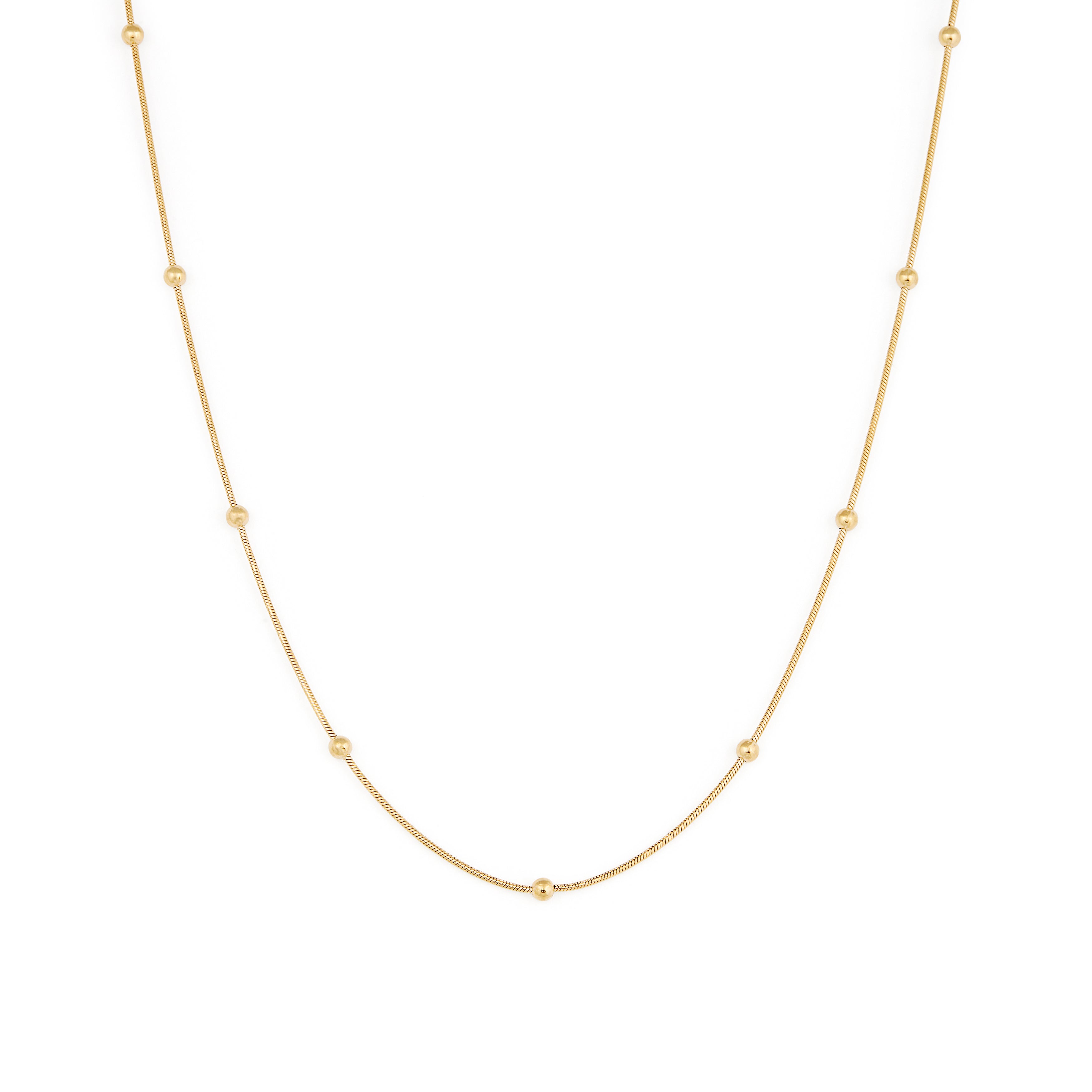 A gold-colored necklace with a chain link design and small spherical embellishments evenly spaced along the length.