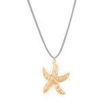 A gold-colored starfish pendant on a faux suede cord necklace.