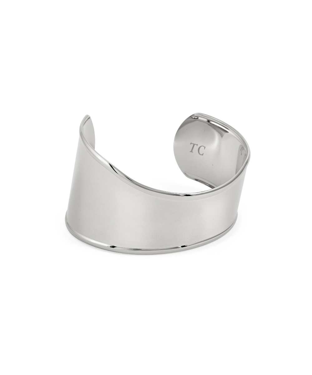 A wide, polished Silver statement cuff bracelet featuring a smooth, asymmetrical wavy design and an open back, with the letters "TC" subtly engraved on the inner curve, isolated on a white background.