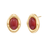 Gold earrings with red stones on a white background