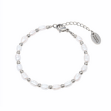 A silver bracelet featuring freshwater pearls and small silver beads, with a lobster clasp closure.