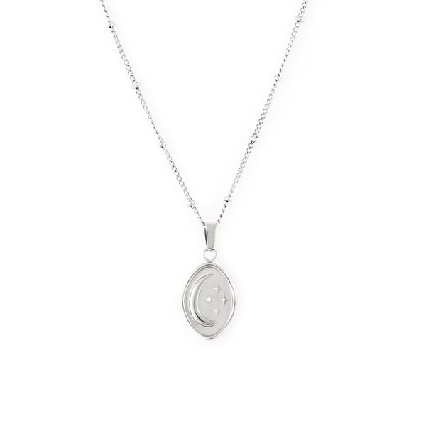  A silver-colored necklace with a beaded chain and an abstract shaped pendant featuring an embossed moon and star with a tiny cubic zirconia stone. Collier Céleste - Argent