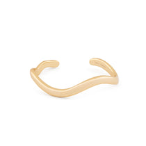 A gold-colored cuff bracelet with an organic shape, displayed against a white background.