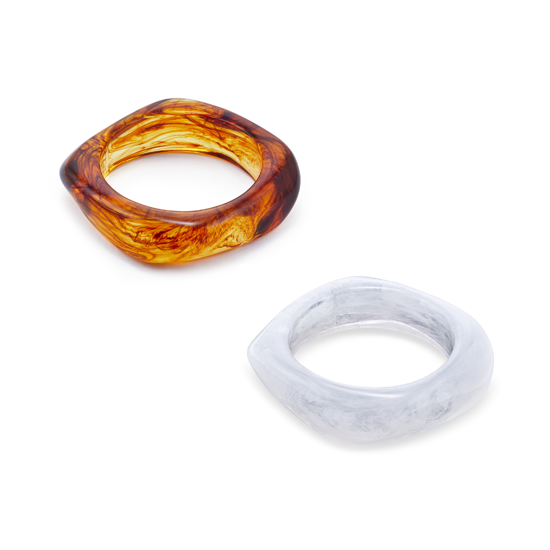 Two geometrically shaped Bangles, one brown and one white, on a white background