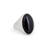 A silver signet ring featuring a large, polished oval black onyx stone, photographed on a seamless white background.