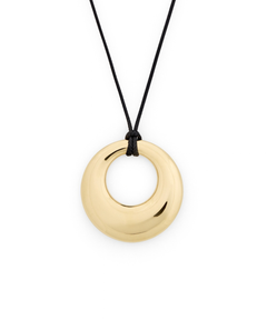 A polished gold-tone circular pendant necklace on a black cord, shown against a plain white background.