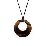 A circular pendant necklace made of polished tiger's eye with natural brown and black banded patterns, suspended from a simple black cord against a solid white background.
