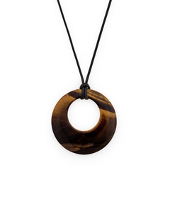 A circular pendant necklace made of polished tiger's eye with natural brown and black banded patterns, suspended from a simple black cord against a solid white background.