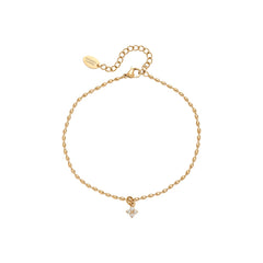 Gold anklet with a small floral charm on a white background