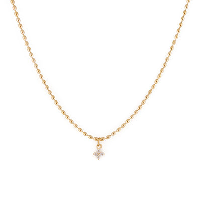 A dainty gold necklace with oval-shaped beads and a cubic zirconia pendant.