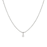 A silver necklace with dainty oval-shaped beads and a cubic zirconia pendant.