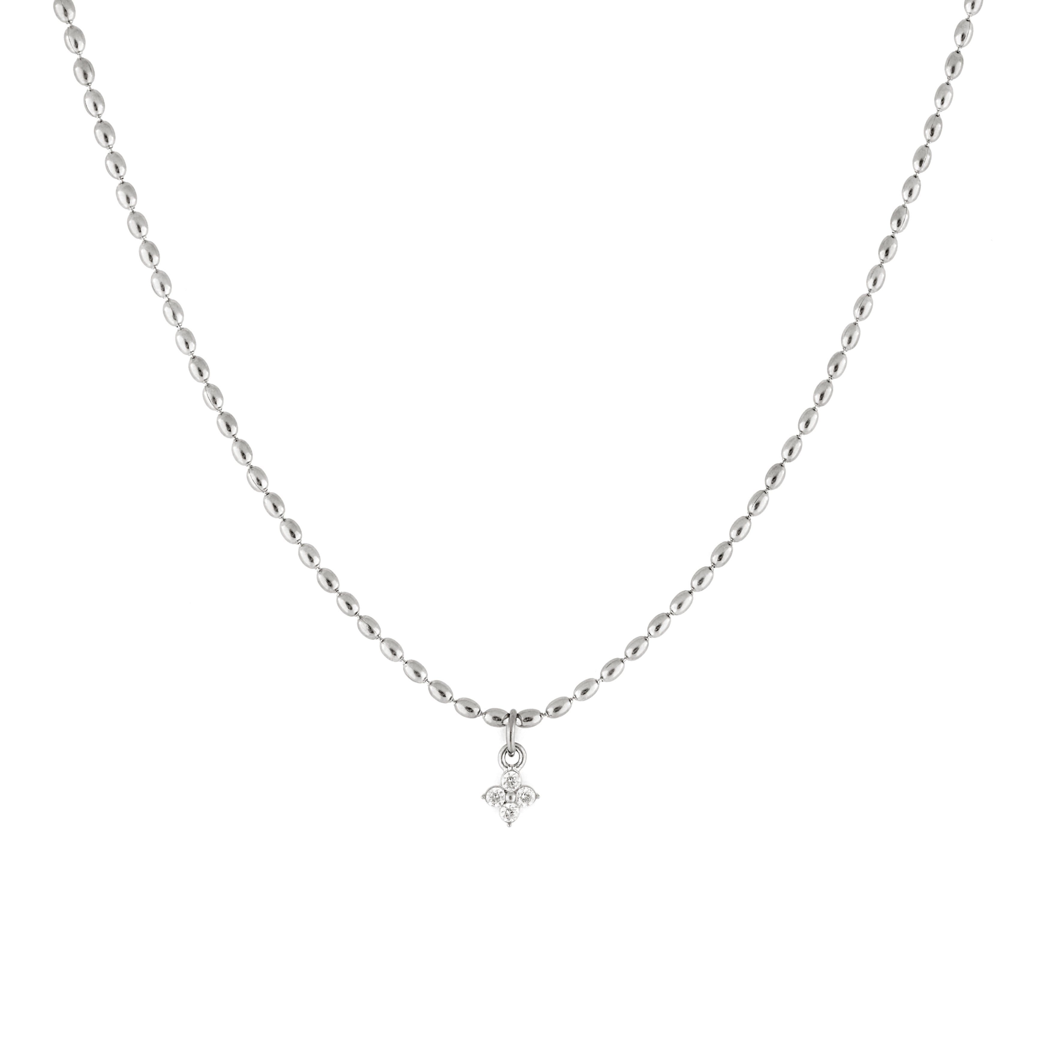 A silver necklace with dainty oval-shaped beads and a cubic zirconia pendant.