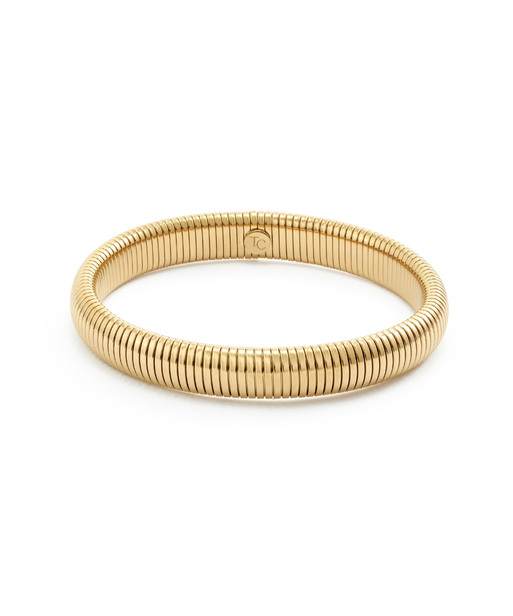 Chunky gold gaspipe bangle bracelet with a ribbed tubogas texture, isolated on a white background.