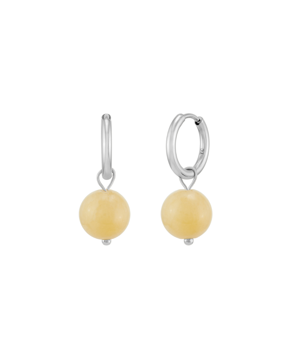 Pair of silver huggie hoop earrings featuring dangling round yellow gemstone beads, isolated on a white background.