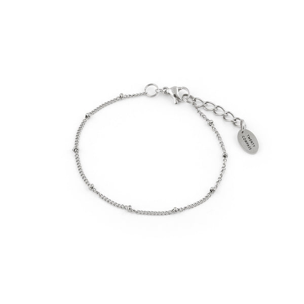 A silver bracelet with a delicate chain and dainty beads, featuring a small tag charm. Sublime Bracelet - Silver