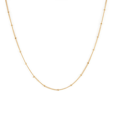 A dainty gold necklace with small spherical embellishments throughout.