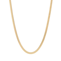 A gold-colored herringbone chain necklace laid out on a plain background.