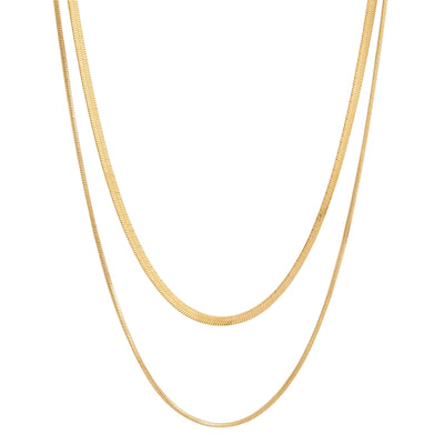 Two gold herringbone chain necklaces, one slightly longer than the other, laid vertically against a white background