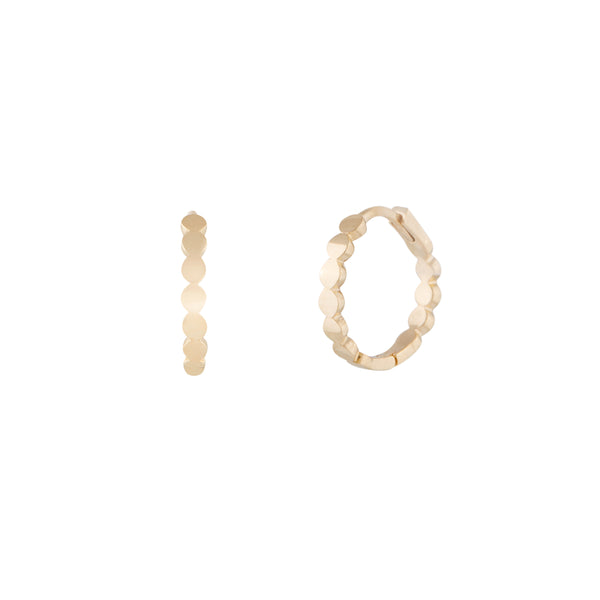 A pair of 14 karat gold hoop earrings with a uniform dotted finish. Dotted Hoops - 14 Karat Gold